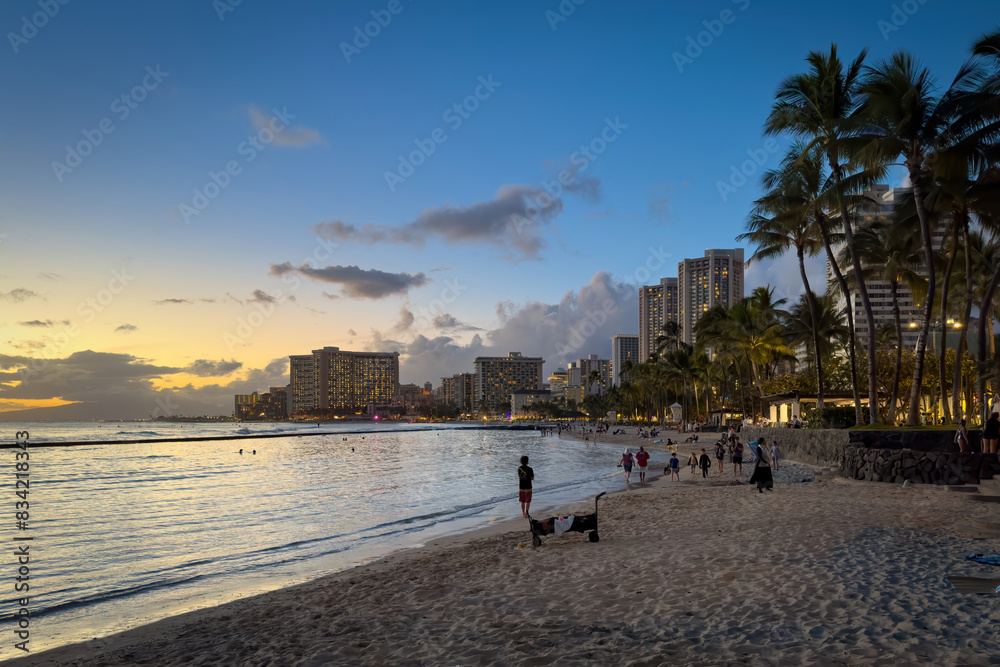 Scenic view of Waikiki Beach in Honolulu on the Hawaiian island of Oahu, USA after sunset against colorful sky with clouds Scenic view of Waikiki Beach in Honolulu on the Hawaiian island of Oahu, USA after sunset against colorful sky with clouds