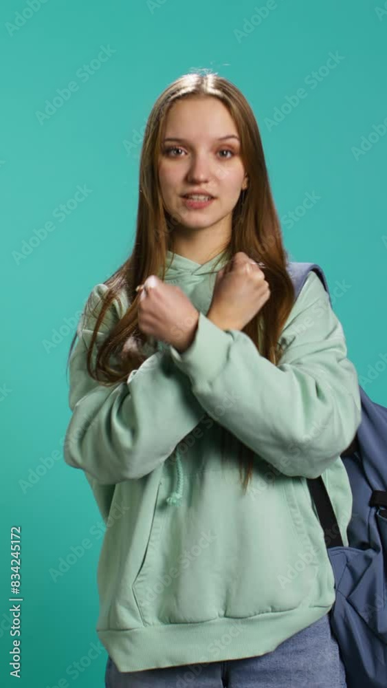 Vertical video Assertive woman shows letter X with arms crossed, staying in warrior stance, showing fierceness. Firm young person using negative body language to signal rejection, studio background Vertical video Assertive woman shows letter X with arms crossed, staying in warrior stance, showing fierceness. Firm young person using negative body language to signal rejection, studio background