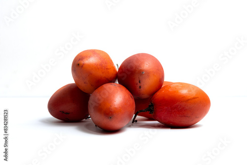 Close-up, still life style of a pile of juicy, ripe red Andes tree tomatoes - tamarillos on a white background photo