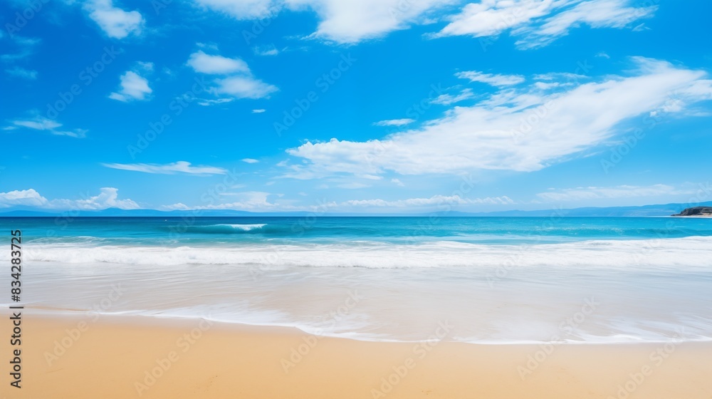 A picturesque beach featuring clear blue skies, sandy shores, and gentle ocean waves