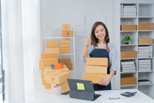 SME entrepreneur Small business entrepreneurs Online selling ideas, Happy  Asian business owner work on computer and a box at home, delivery SME procurement package box deliver to customers, © Tj