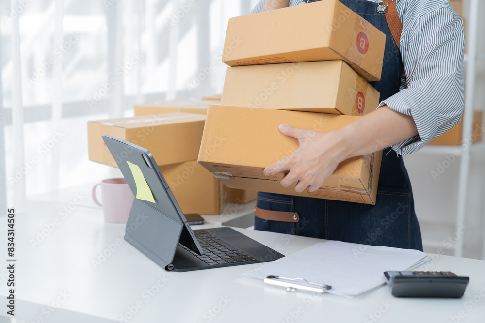 SME entrepreneur Small business entrepreneurs Online selling ideas, Happy  Asian business owner work on computer and a box at home, delivery SME procurement package box deliver to customers,