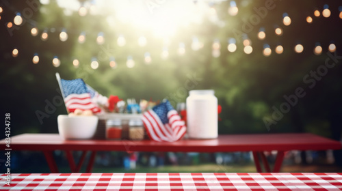 A table with a red and white checkered cloth and a few American flags on it