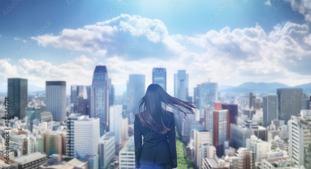 日本の街・都市・朝日を受けたオフィスビル群を前に佇み風を受けて髪をなびかせる会社員の女性の出勤 就職・ビジネス・はじまり・決意・目標・挑戦のイメージ 日本の街・都市・朝日を受けたオフィスビル群を前に佇み風を受けて髪をなびかせる会社員の女性の出勤 就職・ビジネス・はじまり・決意・目標・挑戦のイメージ