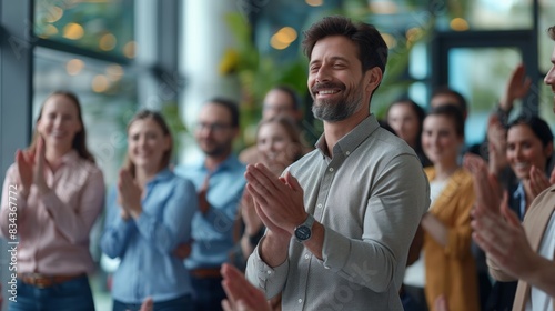 Smiling man being applauded by colleagues during presentation in office. photo