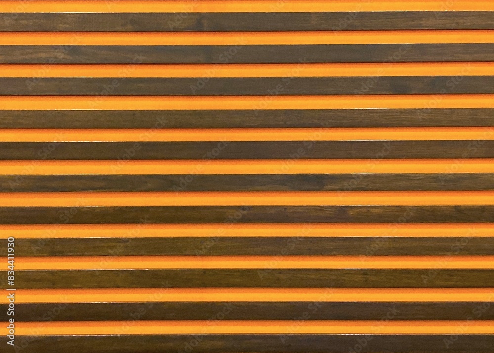 Fototapeta premium Wooden brown stripe on bright orange glass with light and shadow for modern, vivid background
