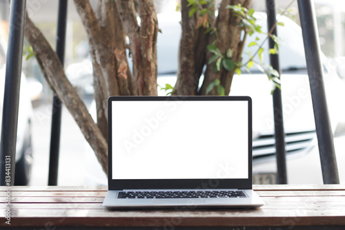 Laptop computer on desk at office or co-working space, Laptop with white blank on screen and blurred background , working space concept.