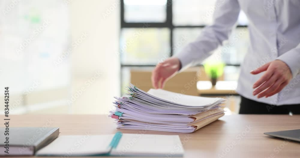 Intern takes stack of business documents from desk