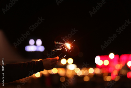 Burning sparkler against bl...