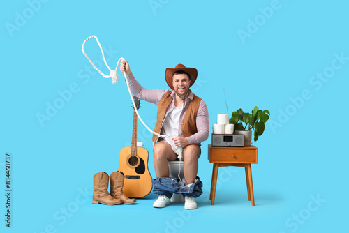 Young cowboy with rope sitt...
