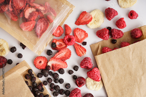 Fototapeta Naklejka Na Ścianę i Meble -  Craft bags with tasty freeze-dried fruits on white background