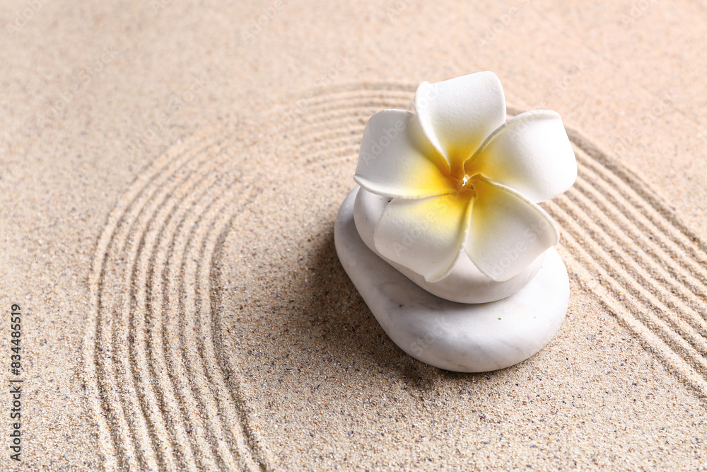 Stones and plumeria on sand with lines Stones and plumeria on sand with lines