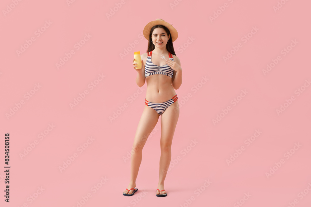 Young woman in swimsuit with sunscreen cream on pink background Young woman in swimsuit with sunscreen cream on pink background