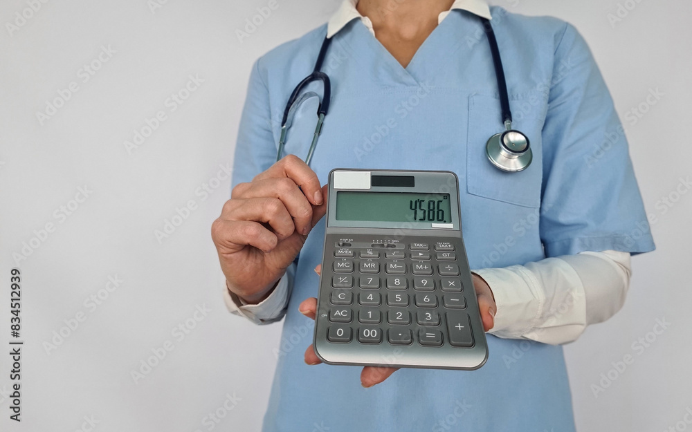 A Healthcare Professional Holding a Calculator Against a White Background