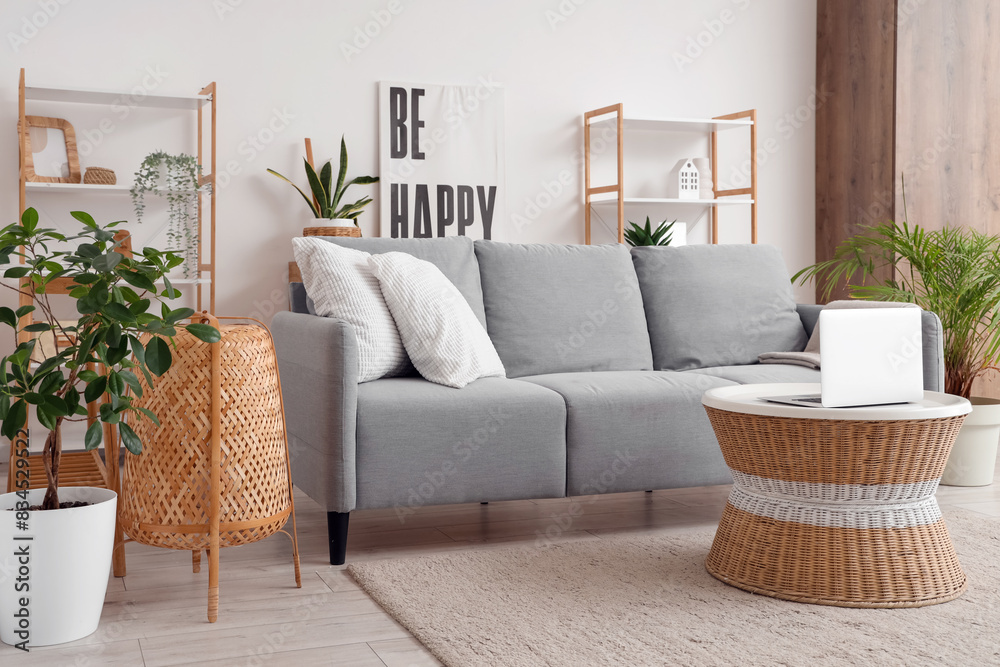 Interior of living room with sofa and laptop on rattan table Interior of living room with sofa and laptop on rattan table