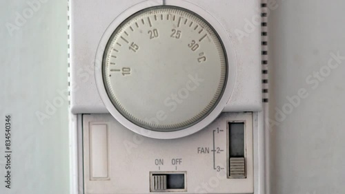 A white thermostat to control temperature of air condition
