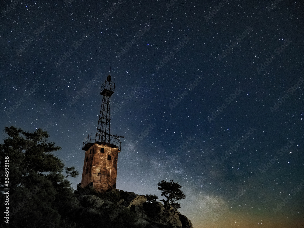 lighthouse under scarry sky at night astrophotography