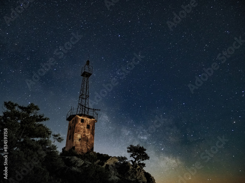 Obraz na płótnie lighthouse under scarry sky at night astrophotography w salonie