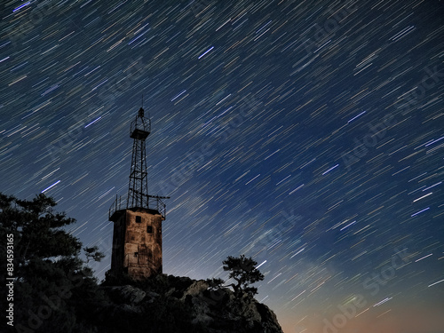 Obraz na płótnie lighthouse under scarry sky at night astrophotography w salonie