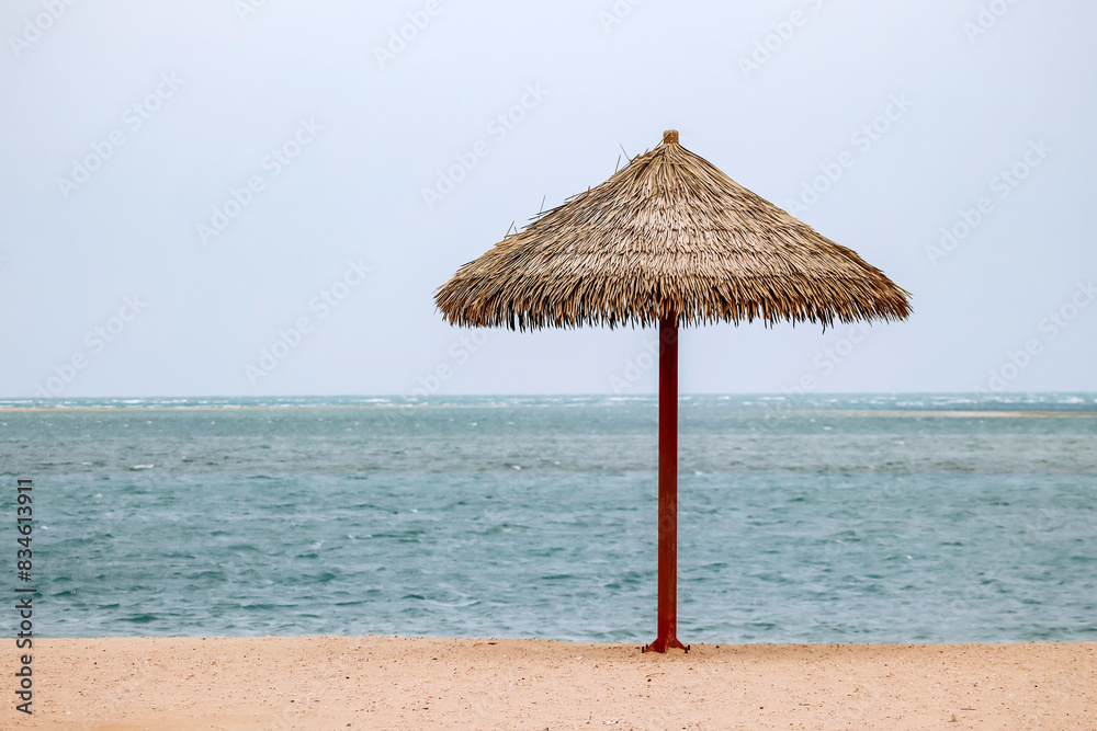 Straw umbrella on the beach in Doha on a cloudy day Straw umbrella on the beach in Doha on a cloudy day