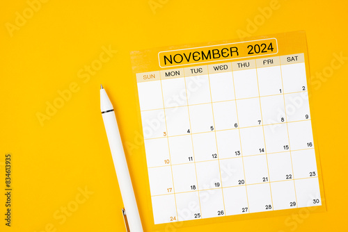 November 2023 Monthly calendar for 2024 year with pen on yellow background. © gamjai