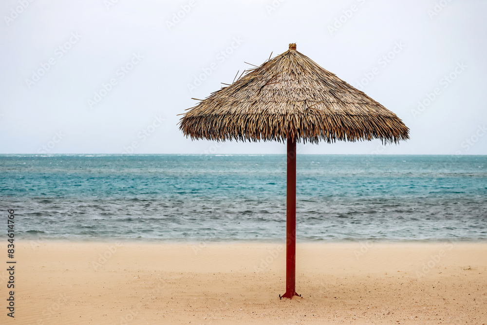 Straw umbrella on the beach in Doha on a cloudy day Straw umbrella on the beach in Doha on a cloudy day