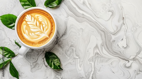  A cup of cappuccino atop a marble surface, adorned with a single leaf Green foliage encircles the scene, framing the cup and its steaming photo