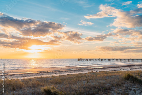 Glenelg Beach with jetty and people silhouettes in the background at sunset  South Australia