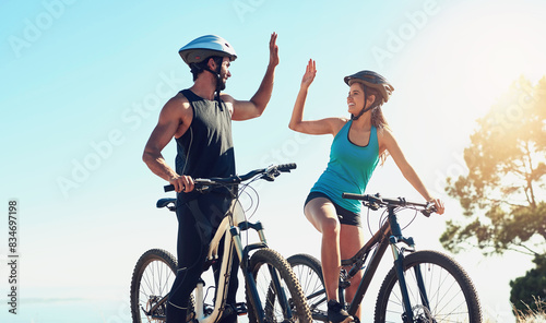 Man, woman or together on bicycle with high five in countryside for exercise, celebrate for workout goal. Team, people or bike with hands for training success on mountain, healthy motivation in sport
