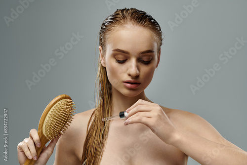 Young woman with long wet hair using brush.