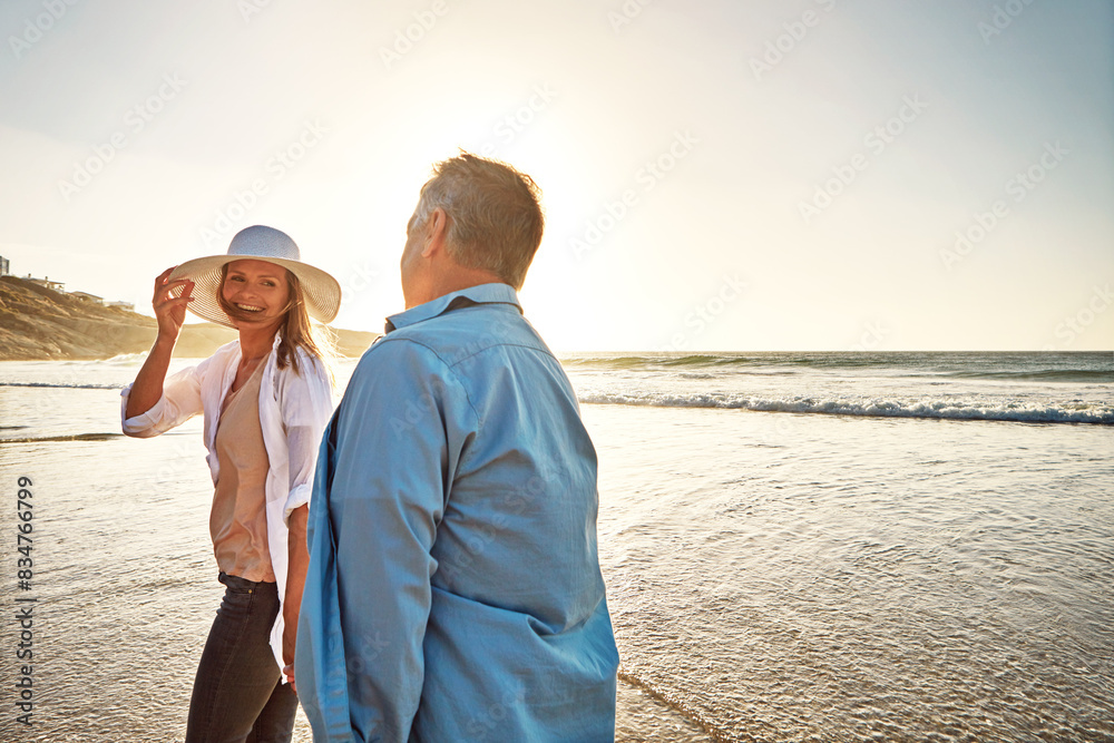 Happy couple, walk and holding hands on beach for vacation on island or coast for getaway, travel and holiday. Woman, man and bonding for love or marriage anniversary by ocean at sunrise in Indonesia