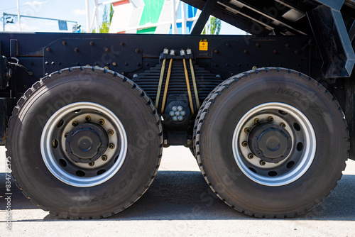 Leaf spring with tires of commercial truck, suspension and bolts for oversize vehicles, cargo and construction mode of transports, heavy industry, detail
