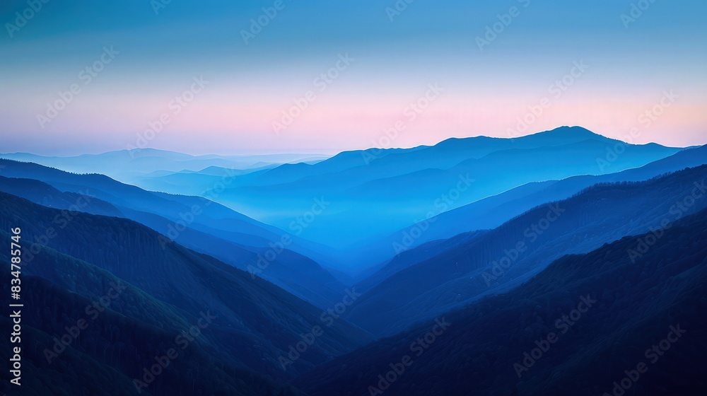 Obraz premium A serene twilight scene in the Smoky Mountains, the hills and valleys bathed in a tranquil blue hue as the last light of day fades.