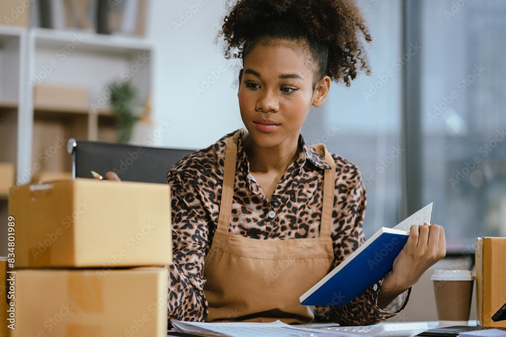 Startup or small business entrepreneur in e commerce, or logistics in remote startup at home. African American female owner selling online on the Internet, SME, shipping boxes, store success. Startup or small business entrepreneur in e commerce, or logistics in remote startup at home. African American female owner selling online on the Internet, SME, shipping boxes, store success.