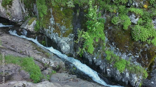 River flowing at the bottom of a ravine with moss and vegetation attachted to the rocks. The Vkadaya river in Vitosha mountain, near Sofia, Bulgaria. photo