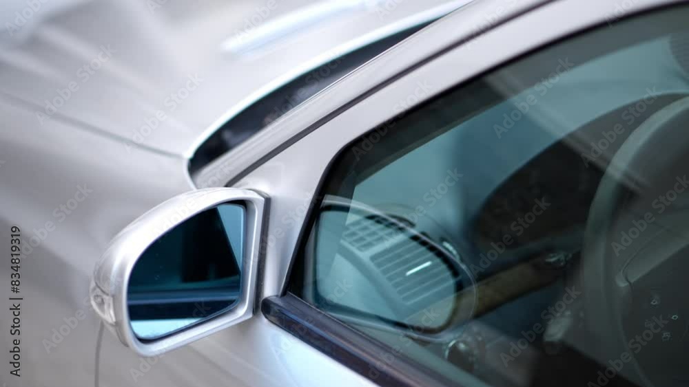 Close up of the mirror and the front window of a silver car