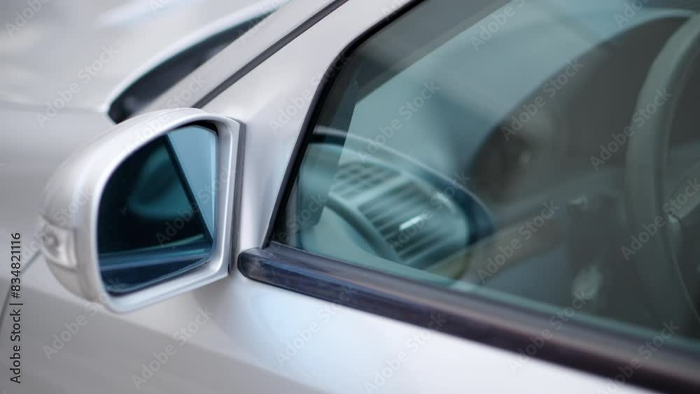 Close up of the mirror and the front window of a silver car Close up of the mirror and the front window of a silver car