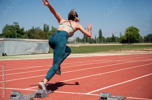 Female athlete starting a sprint on a track