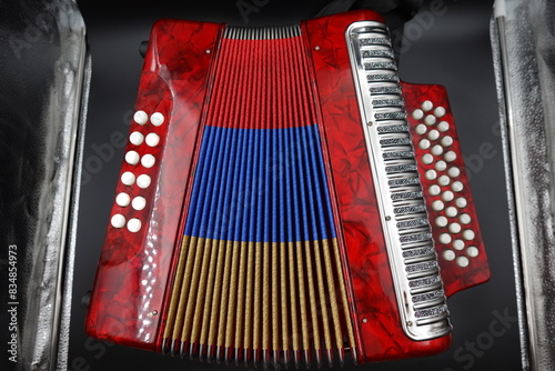 Cuadro en lienzo A vibrant red Colombian vallenato accordion featuring the colors of the Colombian flag (red, yellow, and blue)