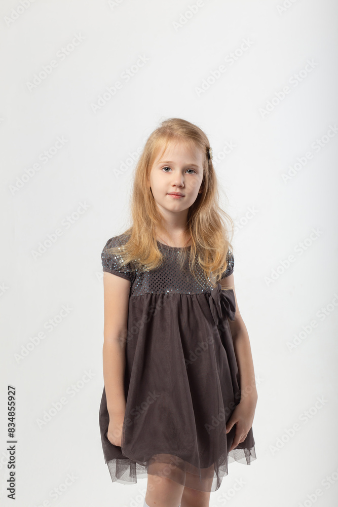 A little blonde girl in a dress and black boots poses A little blonde girl in a dress and black boots poses