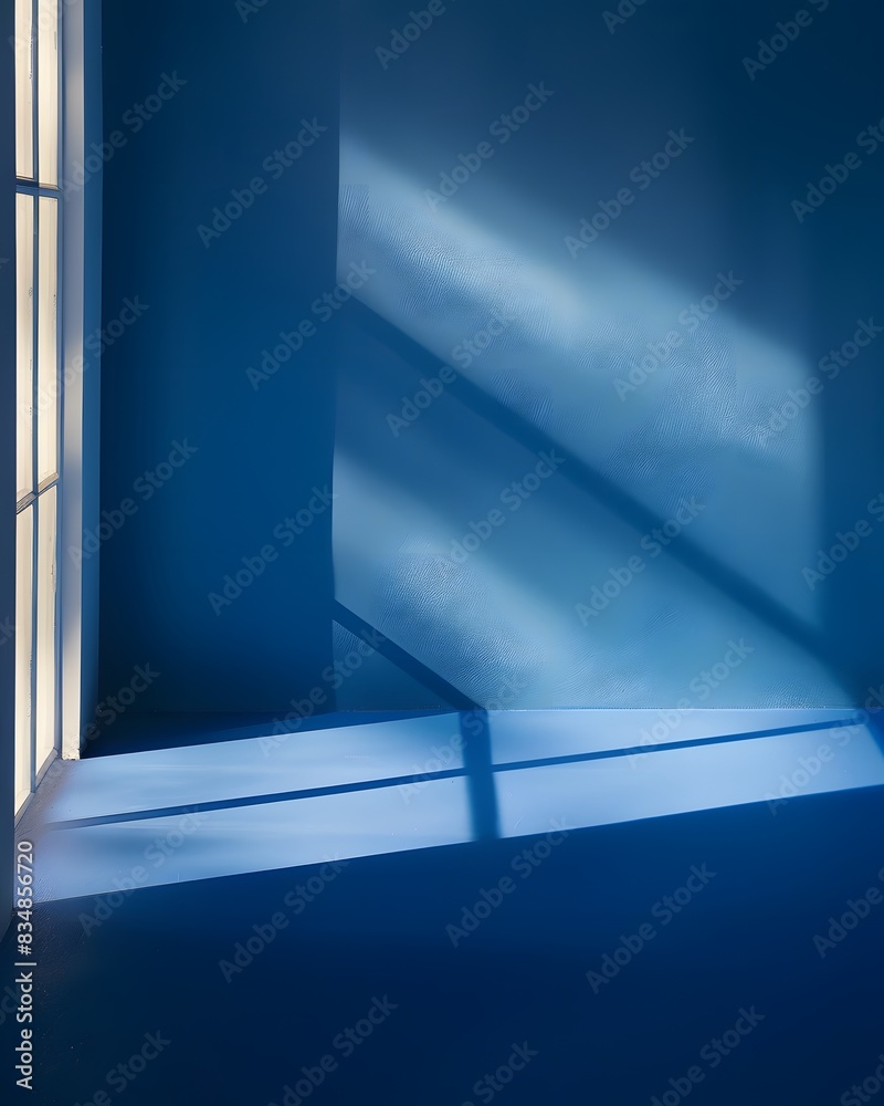 Obraz premium A blue background with the shadow of windows, light and shadows on the wall in a minimalist style