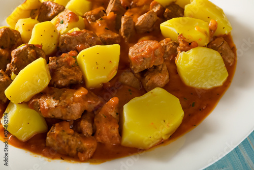meat dish. stewed potatoes with meat goulash lie on a white plate, close-up top view food concept