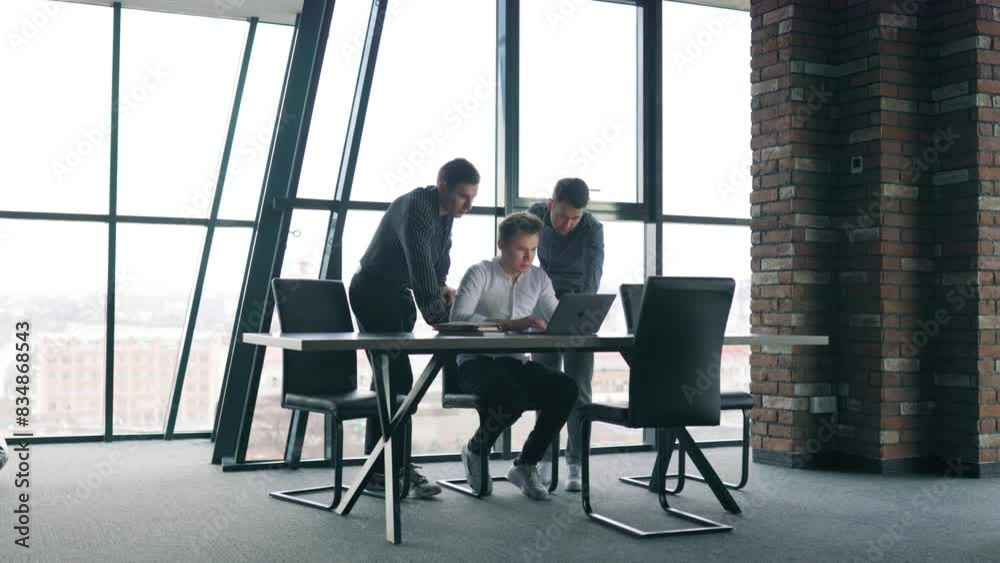 Young businesspeople typing on their laptops in a professional work environment. Young businesspeople typing on their laptops in a professional work environment.