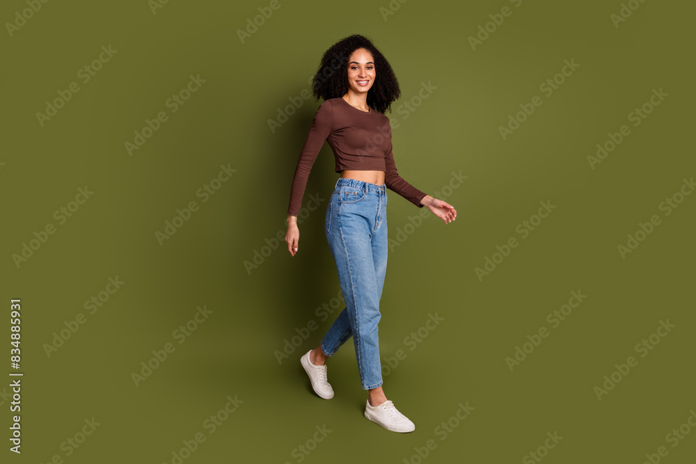 Full body photo of attractive young woman walking dressed stylish brown clothes isolated on khaki color background Full body photo of attractive young woman walking dressed stylish brown clothes isolated on khaki color background