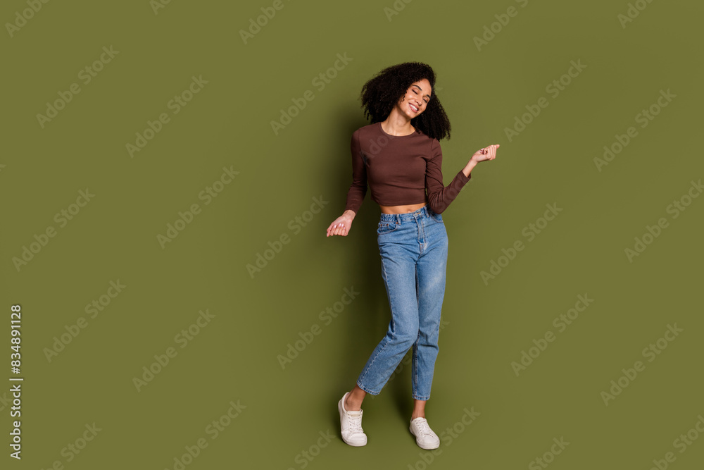 Full length photo of lovely young lady dancing enjoy music dressed stylish brown garment isolated on khaki color background Full length photo of lovely young lady dancing enjoy music dressed stylish brown garment isolated on khaki color background