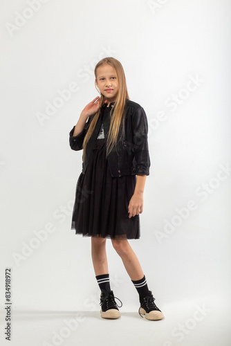 A full-length portrait of a young girl with long brown hair dressed in a hooligan style. © BY-_-BY