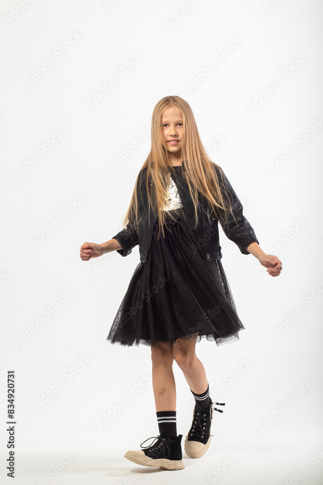 A full-length portrait of dancing young girl with long brown hair dressed in a hooligan style. A full-length portrait of dancing young girl with long brown hair dressed in a hooligan style.