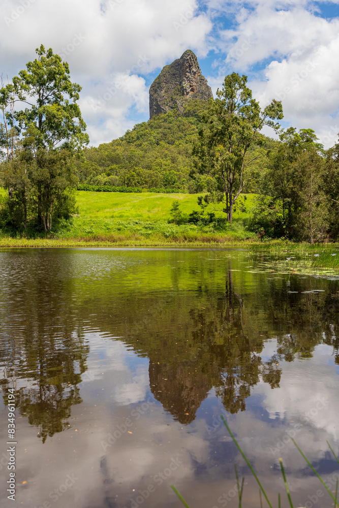 A distant pointed mountain reflected in a still waterhole A distant pointed mountain reflected in a still waterhole