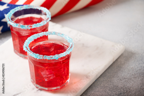 Patriotic red pomegranate margarita cocktail on gray background. Festive beverages for Independence Day July 4th. Close up. Copy space. Rimmed drinks.