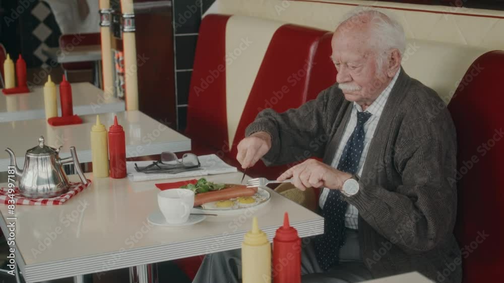 Side shot of moustached Caucasian gentleman in years enjoying traditional English breakfast in 1980s style diner Side shot of moustached Caucasian gentleman in years enjoying traditional English breakfast in 1980s style diner